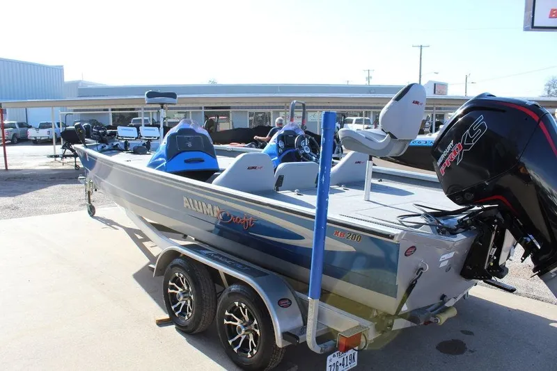 Slide: The Image of 2019 Alumacraft XB 200 boat with trailer, featuring a powerful outboard motor. - 2