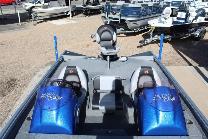 Slide: The Image of 2019 Alumacraft XB 200 boat with blue consoles and seating, displayed outdoors. - 9