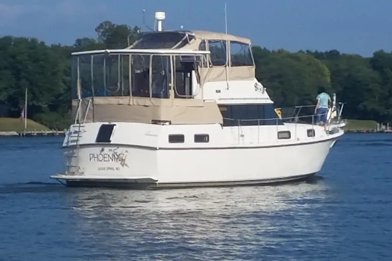 The Image of 1988 Carver 36 Command Bridge yacht cruising on a serene lake. - 0