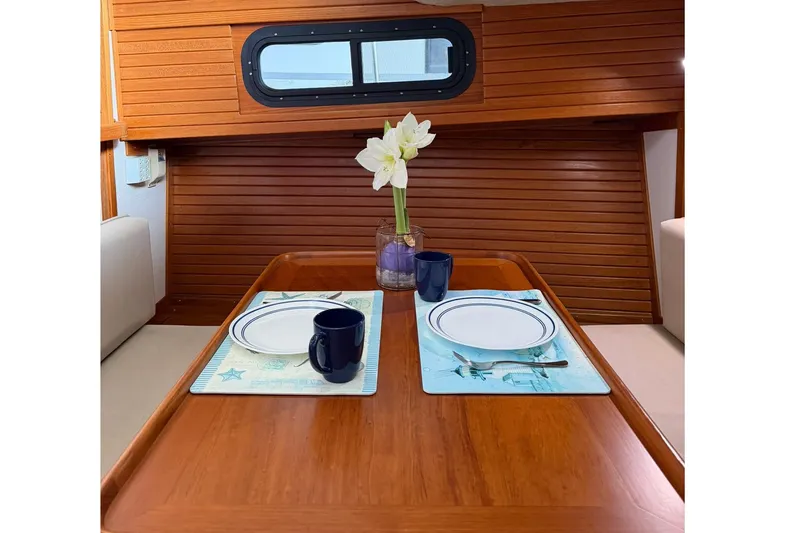 Slide: The Image of Dining area inside 1988 Carver 36 Command Bridge with wooden table and elegant table setting. - 4