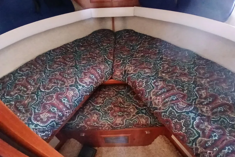 Slide: The Image of 1988 Carver 36 Command Bridge cabin with patterned bedding and wooden accents. - 6