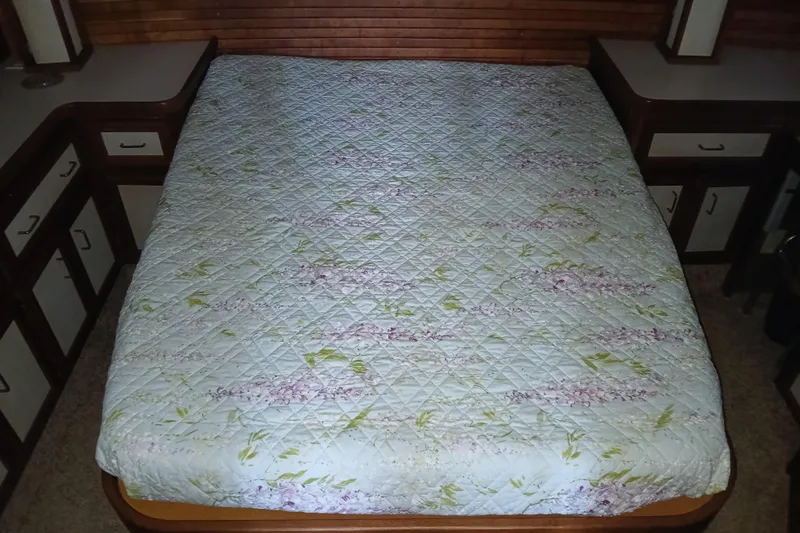 Slide: The Image of Quilted bed in 1988 Carver 36 Command Bridge cabin, surrounded by wooden cabinetry. - 8