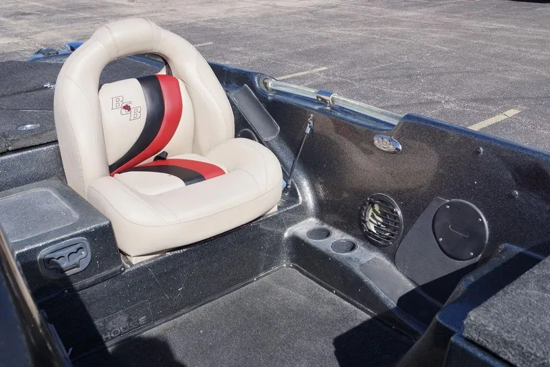 Slide: The Image of 2010 Bass Cat Cougar boat interior with beige and red seat, cup holders, and speaker. - 11