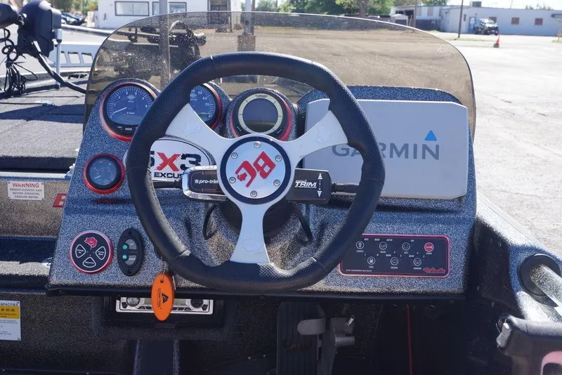 Slide: The Image of Bass Cat Cougar 2010 boat dashboard with steering wheel, gauges, and Garmin navigation system. - 15