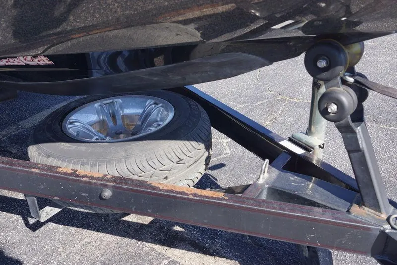 Slide: The Image of 2010 Bass Cat Cougar boat trailer with spare tire on asphalt surface. - 21