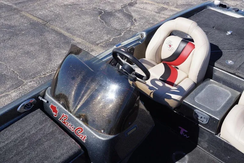 Slide: The Image of 2010 Bass Cat Cougar boat interior with steering wheel and branded seat design. - 8