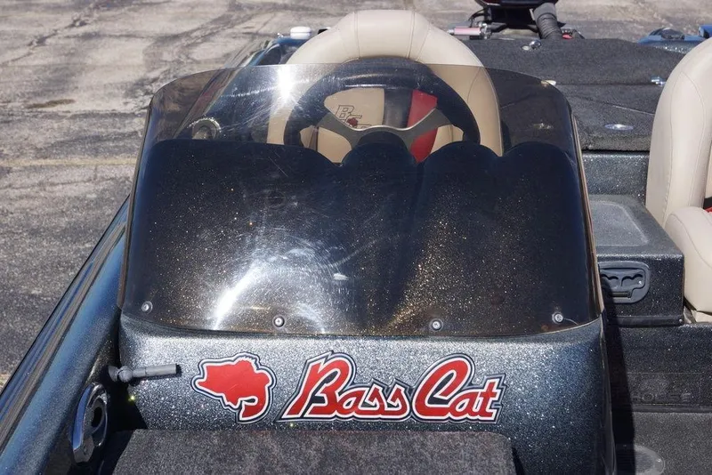 Slide: The Image of 2010 Bass Cat Cougar boat with windshield and logo, featuring beige seats. - 9