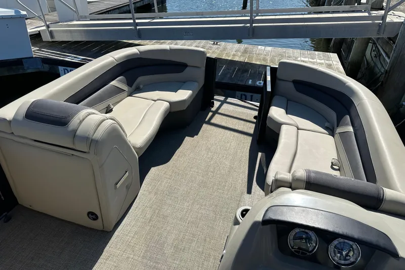 Slide: The Image of 2022 Barletta Cabrio 22CC pontoon boat interior with plush seating at dock. - 10