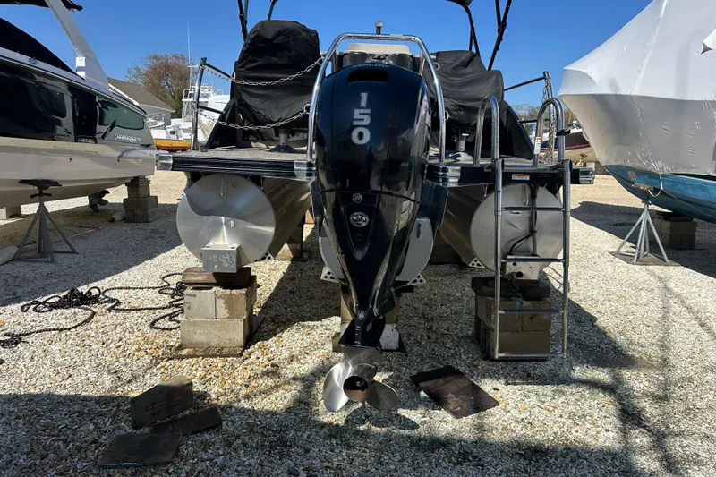 Slide: The Image of 2022 Barletta Cabrio 22CC pontoon boat with 150 HP engine on dry dock. - 22