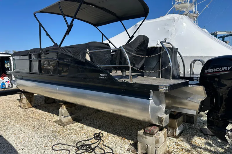 Slide: The Image of 2022 Barletta Cabrio 22CC pontoon boat on blocks, featuring a Mercury outboard motor. - 23