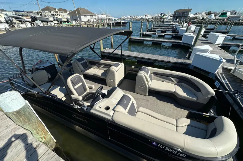 Slide: The Image of 2022 Barletta Cabrio 22CC pontoon boat docked at marina, featuring spacious seating and canopy. - 4