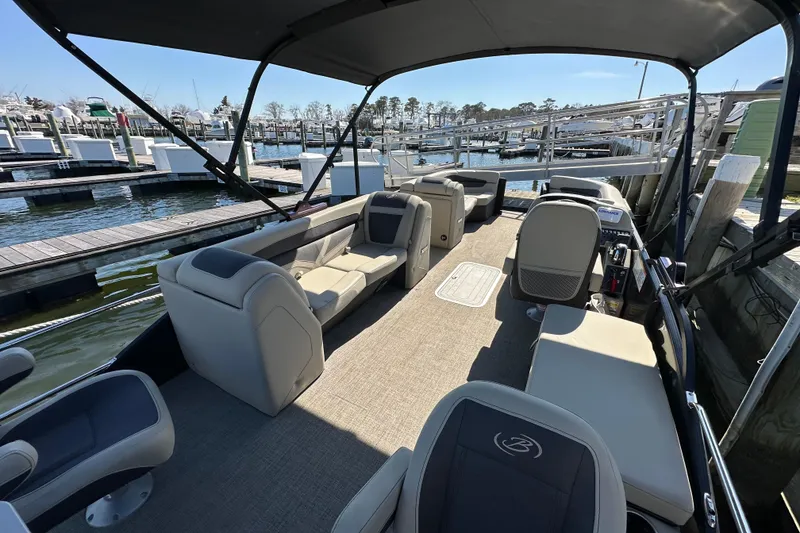 Slide: The Image of 2022 Barletta Cabrio 22CC pontoon boat with spacious seating at a marina dock. - 6