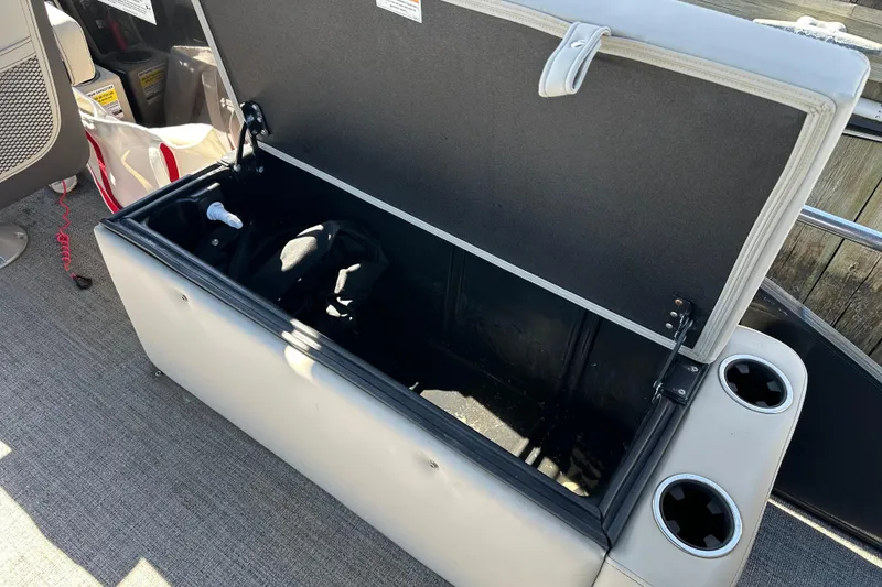 Slide: The Image of Open storage compartment on a 2022 Barletta Cabrio 22CC boat with cup holders. - 8