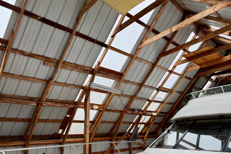 Slide: The Image of Wooden boathouse interior with a 1990 BoatHouse 19x43 model partially visible. - 3