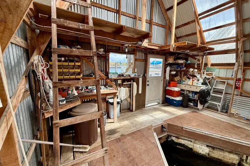 Slide: The Image of Wooden boathouse interior with tools, shelves, and a ladder, BoatHouse model 19x43, built in 1990. - 5