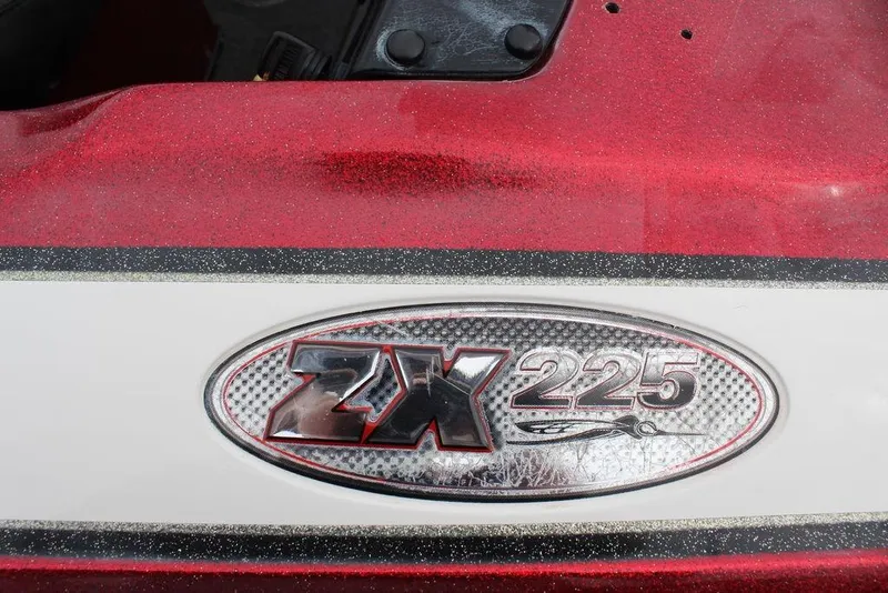 Slide: The Image of 2002 Skeeter ZX225 boat emblem on a red and white surface. - 10