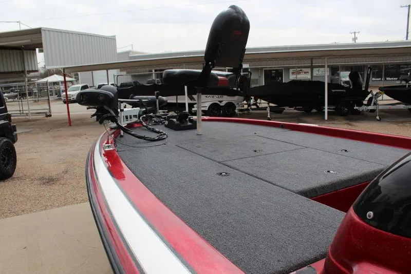 Slide: The Image of 2002 Skeeter ZX225 bass boat with red and gray deck, parked outdoors. - 15