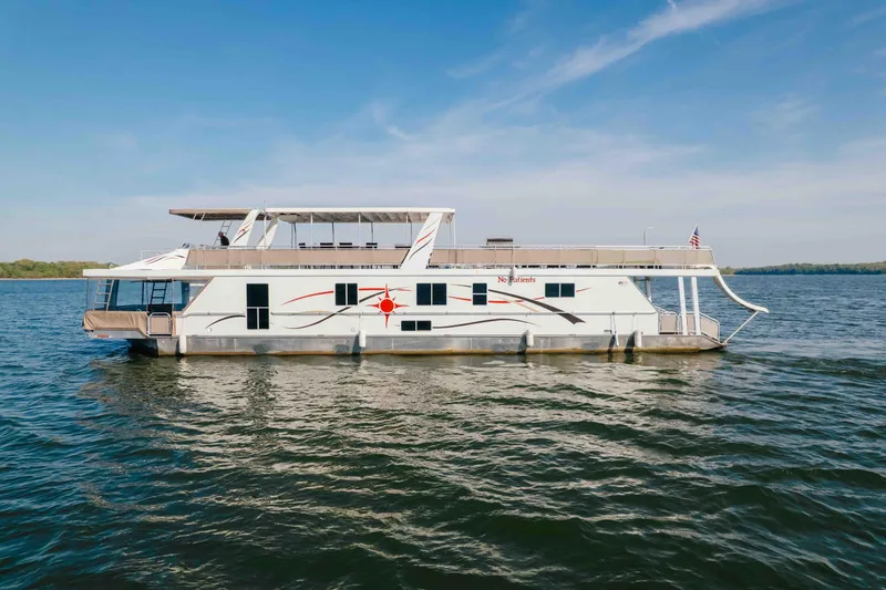 The Image of Houseboat Horizon 18x85, 2009 model, cruising on a serene lake under a clear blue sky. - 0