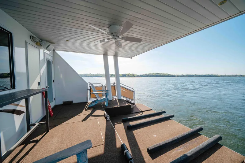 Slide: The Image of Covered deck of 2009 Horizon 18x85 houseboat overlooking serene lake waters. - 15
