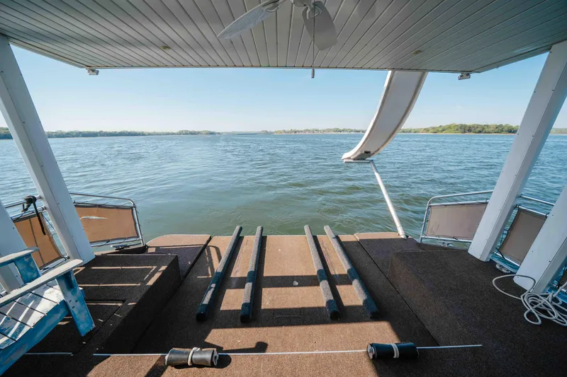 Slide: The Image of Rear view of 2009 Horizon 18x85 houseboat with slide, overlooking serene lake waters. - 19