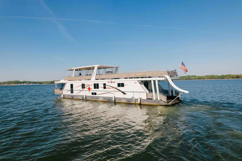 Slide: The Image of Houseboat Horizon 18x85, 2009 model, cruising on a serene lake under a clear blue sky. - 2