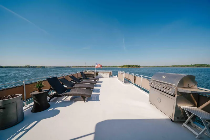 Slide: The Image of Spacious deck of 2009 Horizon 18x85 yacht with lounge chairs and grill, overlooking serene water. - 20
