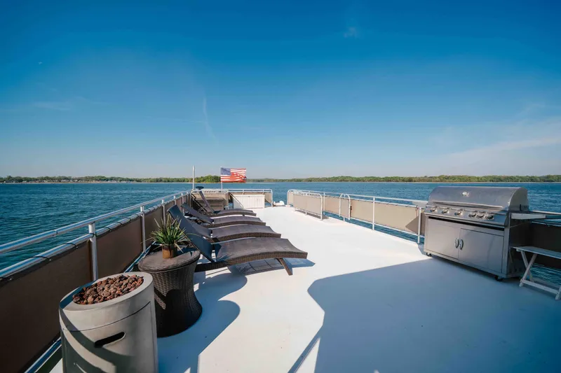 Slide: The Image of Spacious deck of 2009 Horizon 18x85 houseboat with loungers and grill, overlooking serene lake. - 21