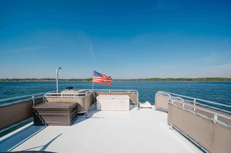Slide: The Image of Rooftop deck of 2009 Horizon 18x85 houseboat with American flag, overlooking serene lake. - 22