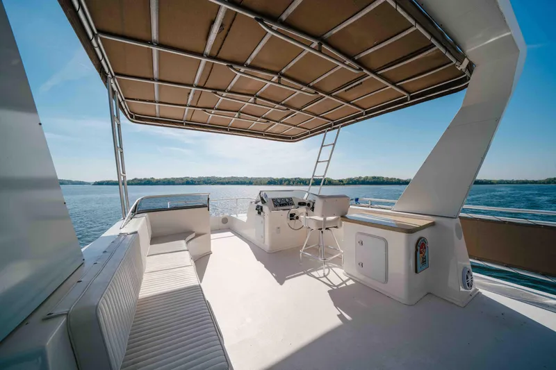 Slide: The Image of Spacious deck of 2009 Horizon 18x85 yacht with seating and helm, overlooking serene waters. - 24