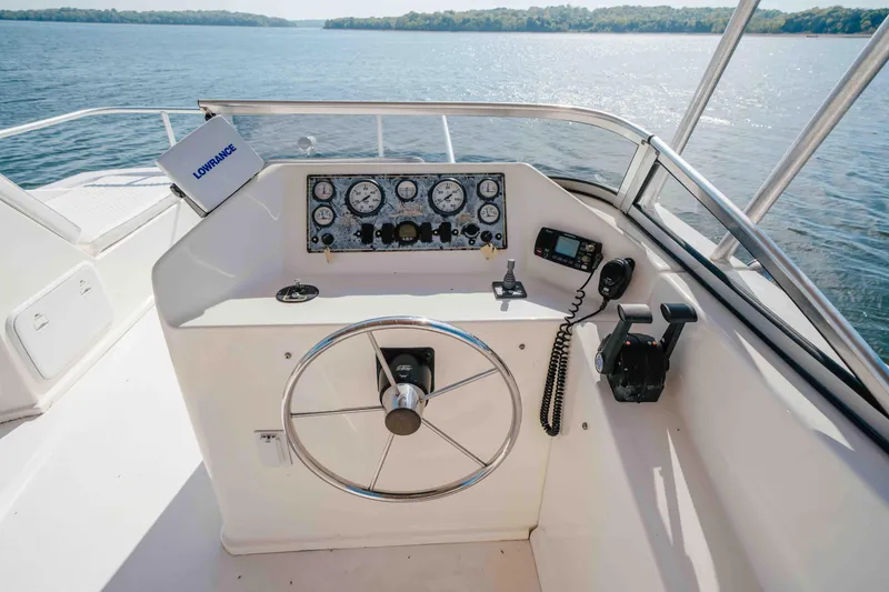 Slide: The Image of Steering console of a 2009 Horizon 18x85 boat with navigation equipment, overlooking a serene lake. - 26