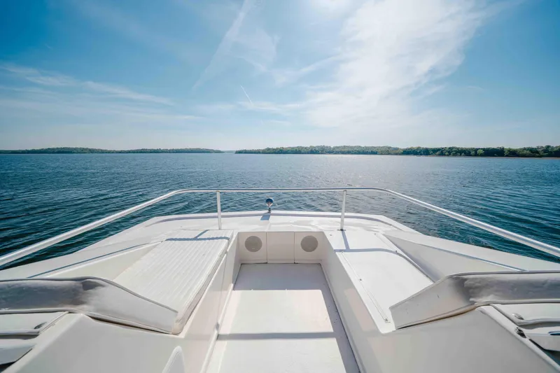 Slide: The Image of Front deck view of 2009 Horizon 18x85 boat on a serene lake under clear skies. - 29