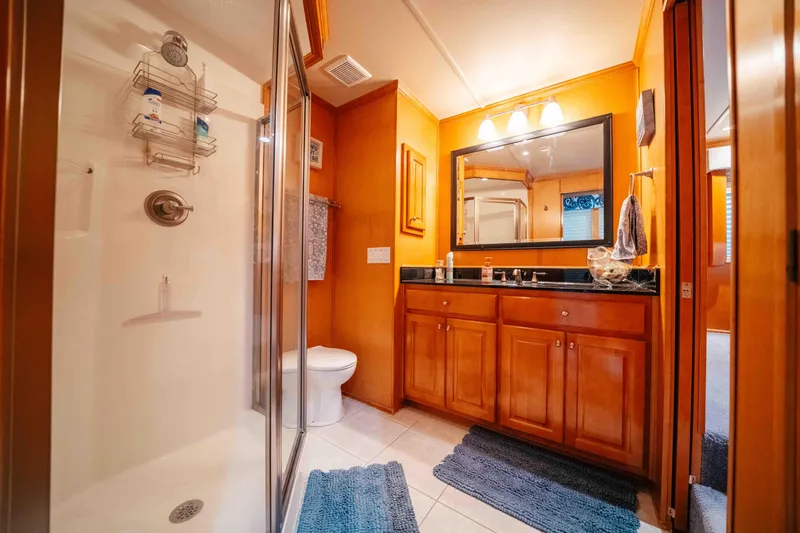 Slide: The Image of Luxurious bathroom in 2009 Horizon 18x85 houseboat with wooden cabinets and glass shower. - 46