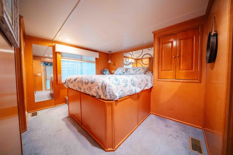 Slide: The Image of Cozy bedroom in 2009 Horizon 18x85 houseboat with wooden cabinetry and patterned bedding. - 48