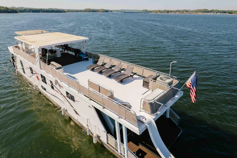 Slide: The Image of Luxurious 2009 Horizon 18x85 houseboat cruising on a serene lake with sun loungers. - 6