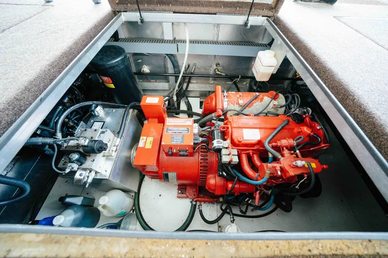 Slide: The Image of Engine compartment of a 2009 Horizon 18x85 boat, featuring a red motor and various components. - 63