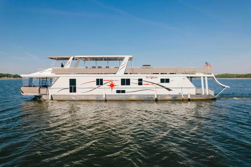 Slide: The Image of Luxurious 2009 Horizon 18x85 houseboat cruising on a serene lake under a clear blue sky. - 9