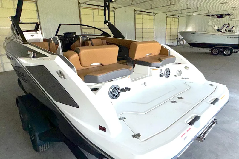 Slide: The Image of 2023 Scarab 255 ID boat with tan seating in a garage setting. - 12
