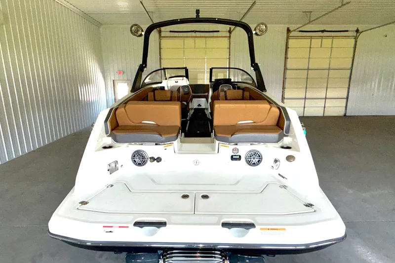 Slide: The Image of 2023 Scarab 255 ID boat interior with brown seating in a spacious garage. - 15