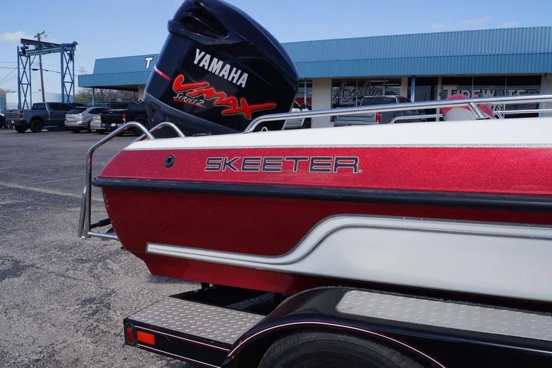 Slide: The Image of 2002 Skeeter SL 210 boat with Yamaha engine, parked outside a dealership. - 10
