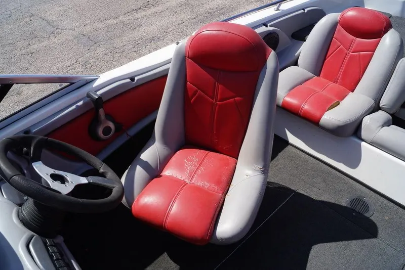 Slide: The Image of 2002 Skeeter SL 210 boat interior with red and gray seating and steering wheel. - 12