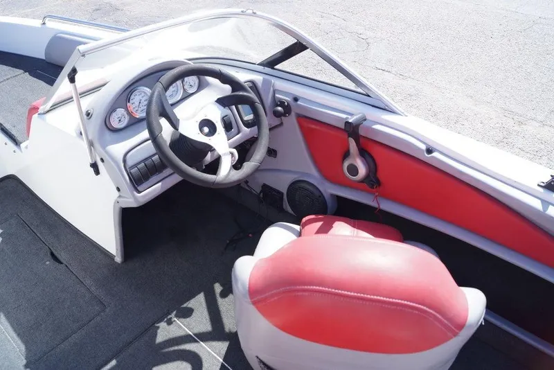 Slide: The Image of Interior of a 2002 Skeeter SL 210 boat with steering wheel and red seating. - 16