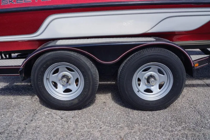 Slide: The Image of Trailer wheels of a 2002 Skeeter SL 210 boat on pavement. - 3