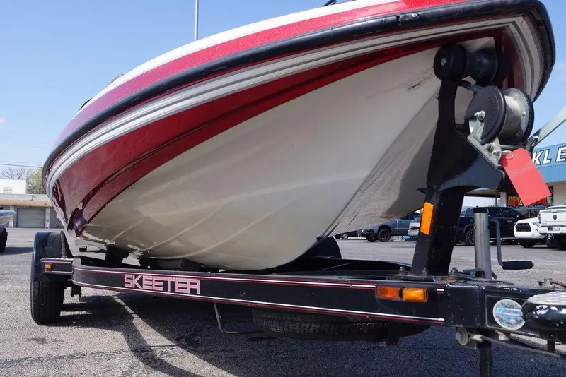 Slide: The Image of 2002 Skeeter SL 210 boat on trailer, red and white hull, parked outdoors. - 4