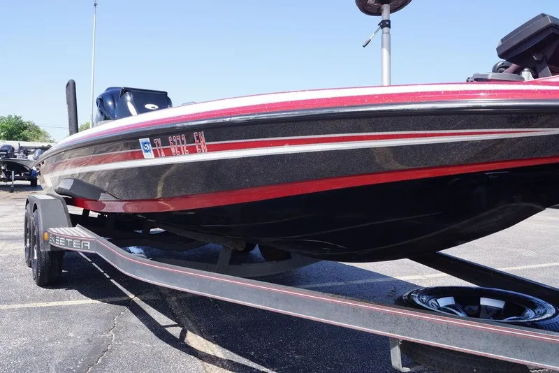 Slide: The Image of 2019 Skeeter ZX250 boat on trailer, featuring sleek red and black design. - 11