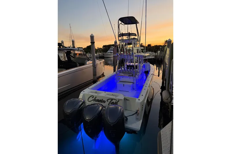 Slide: The Image of 2024 Contender 39 ST boat with blue LED lights docked at sunset. - 12