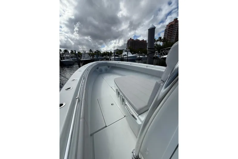 Slide: The Image of 2024 Contender 39 ST boat docked, showcasing sleek design and spacious deck under cloudy skies. - 15
