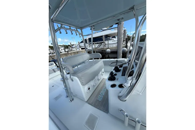 Slide: The Image of 2024 Contender 39 ST boat interior with helm, seating, and controls at a marina. - 22