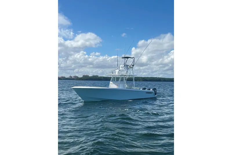 Slide: The Image of 2024 Contender 39 ST boat on open water under clear blue sky. - 3