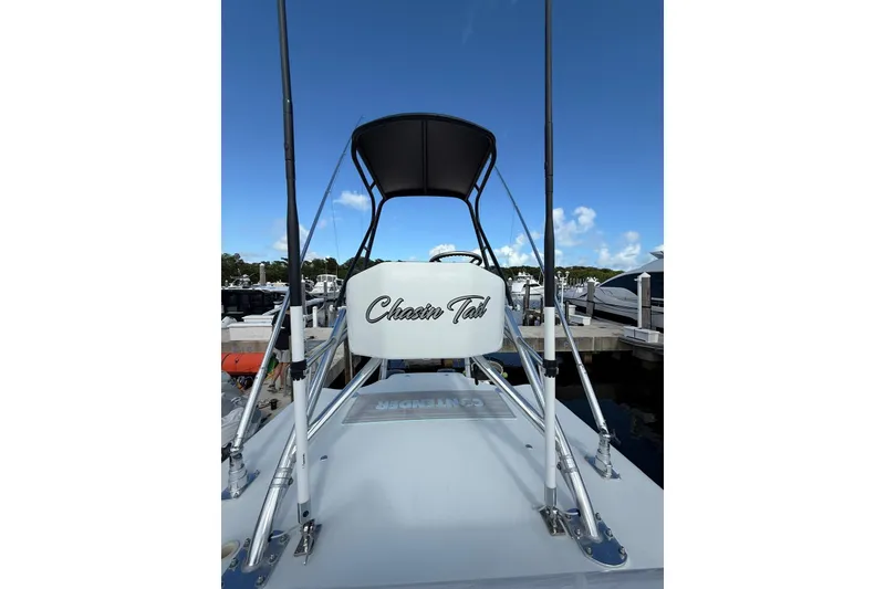 Slide: The Image of 2024 Contender 39 ST boat at marina, featuring sleek design and "Chasin Tail" text. - 30