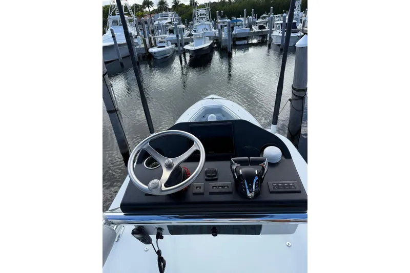Slide: The Image of 2024 Contender 39 ST boat helm with steering wheel and controls at marina. - 32